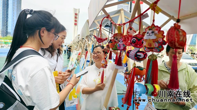 圖1：楊麗平（左3）給游客介紹香囊.jpg