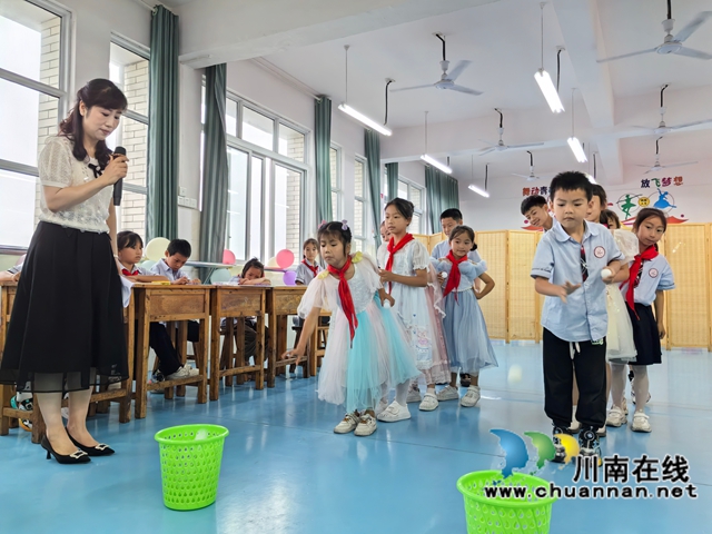 瀘縣農(nóng)民工服務(wù)中心工作人員帶著孩子們玩“投乒乓”游戲.jpg